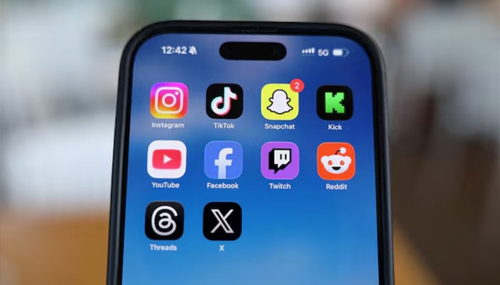 Instagram, TikTok, Snapchat, Kick, YouTube, Facebook, Twitch, Reddit, Threads and X applications are displayed on a mobile phone in this picture illustration taken on December 9, 2025. — Reuters