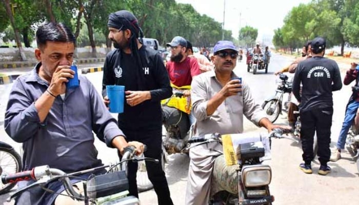 Cantonment Board Hyderabad staff serve cold water to passersby at a heatstroke camp established on Alamgir Road in Hyderabad, May 5, 2026. — APP