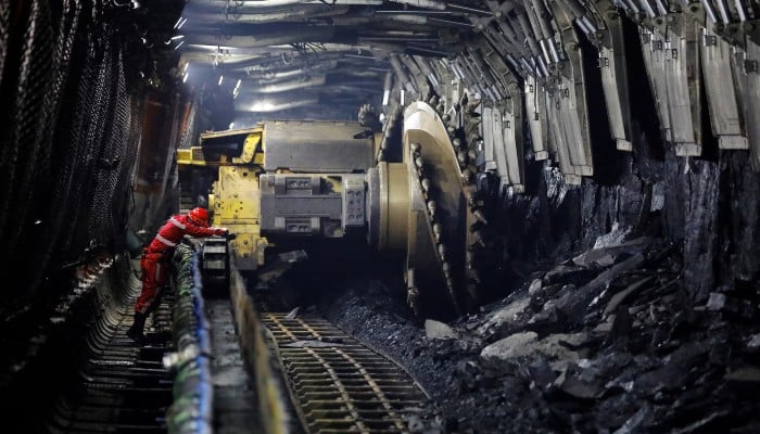 A media reporter uses his camera at an underground coalface where Huawei 5G base stations are deployed to support communication and remote control, at Xiaobaodang Coal Mine, during a Huawei-organised media tour, in Shenmu of Yulin city, Shaanxi province, China, April 26, 2023. — Reuters