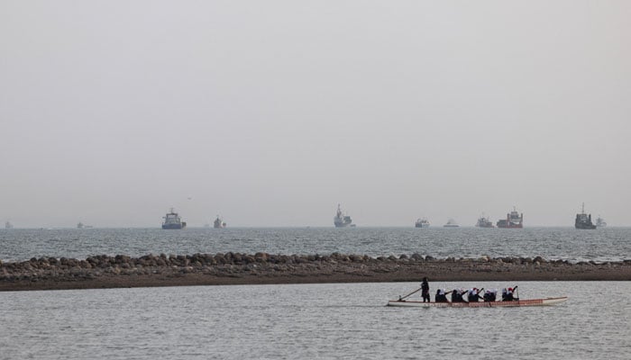 Vessels in the Strait of Hormuz are visible near the beach of Bandar Abbas, Iran, May 22, 2026. — Reuters