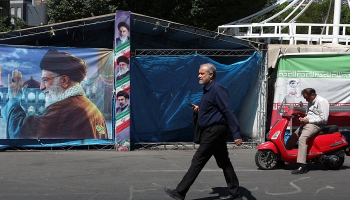 A man walks past a banner with a picture of Irans late Supreme Leader Ayatollah Ali Khamenei, in Tehran, Iran, May 25, 2026. — Reuters