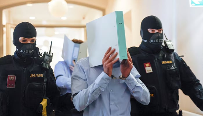 Austrian defendant identified as Beran A, suspected of planning an attack on US singer Taylor Swifts Vienna concert in 2024, is escorted by security personnel in a courtroom for his trial in Wiener Neustadt, Austria, May 28, 2026. — Reuters