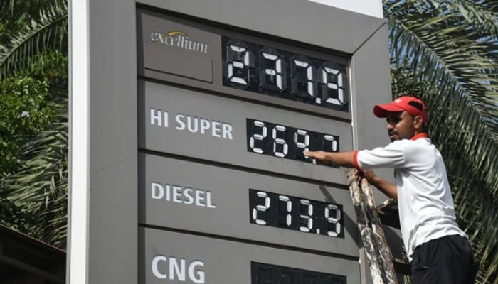 An employee of a petrol station updates the latest fuel prices on the board in Karachi, on October 1, 2025. — Online