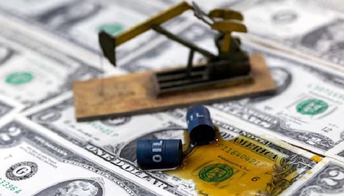 Oil, miniatures of oil barrels, oil pump jack and U.S. dollar banknote are seen in this illustration taken on June 6, 2023. — Reuters
