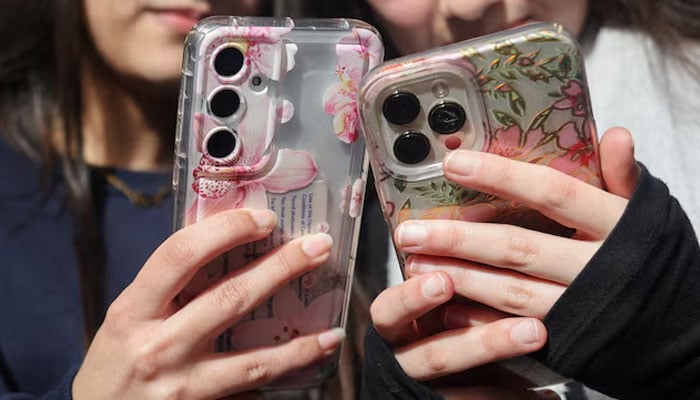 Students from Ricards Lodge High School in Wimbledon pose holding their mobile phones during an interview and discussion with Reuters about their thoughts on a social media ban for under 16s, in London, Britain, February 23, 2026. — Reuters/File