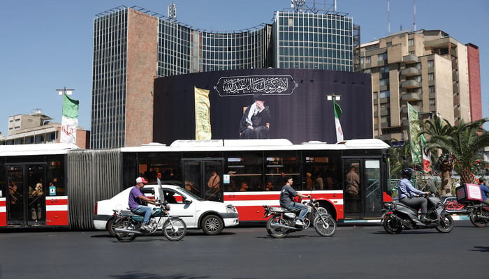 People drive past a billboard with a picture of the late Irans Supreme Leader Ayatollah Ali Khamenei, after U.S. and Iranian officials said they had reached a deal to end their war and reopen the Strait of Hormuz, in Tehran, Iran, June 15, 2026.— Reuters