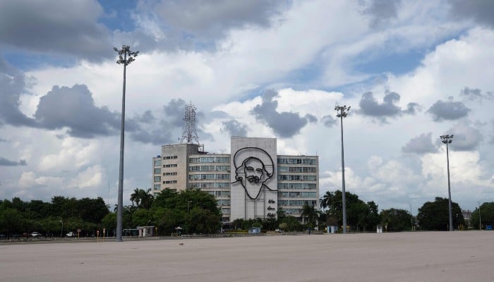 View of the Ministry of Communications building bearing an image of Camilo Cienfuegos, a leading figure of the Cuban Revolution and close ally of Fidel Castro, who disappeared in 1959, at Revolution Square in Havana on June 17, 2026. — AFP
