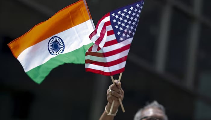 A man holds the flags of India and the US while people take part in the 35th India Day Parade in New York August 16, 2015. — Reuters