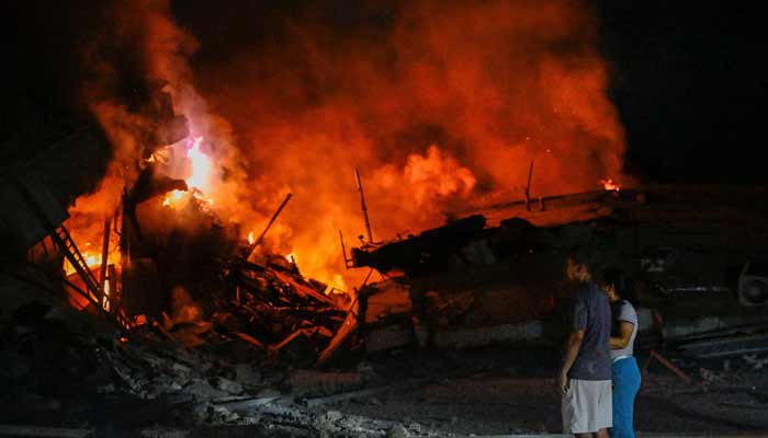 People stand near destroyed buildings after an earthquake, in La Guaira, Venezuela, June 25, 2026.— Reuters
