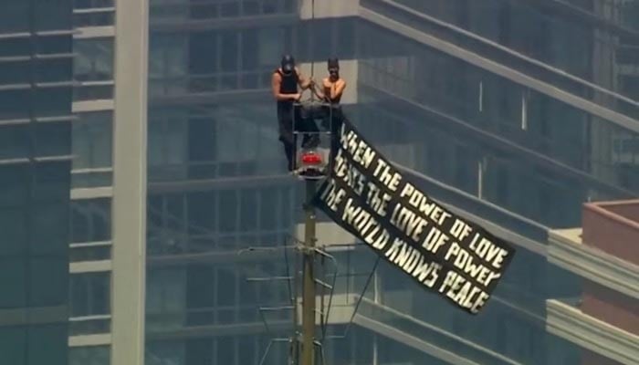 Two people display a banner atop the Empire State Building in the Manhattan borough of New York, US, July 1, 2026. — Reuters