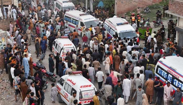 Local people and a rescue ambulance parked at the site where children reportedly died after a tuition centre roof collapsed in Lahore, Pakistan, June 30, 2026. — Reuters